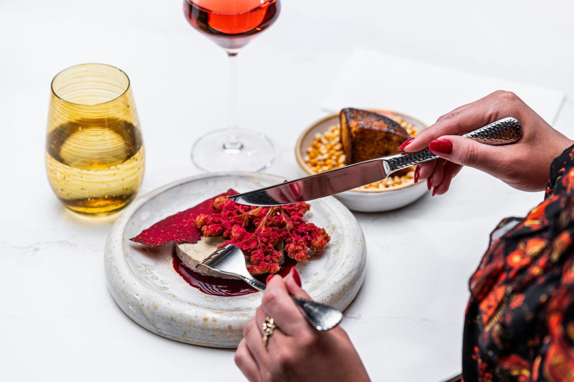 Prague Marriott Hotel Exterior photo A woman using a knife and fork to cut into a dessert
